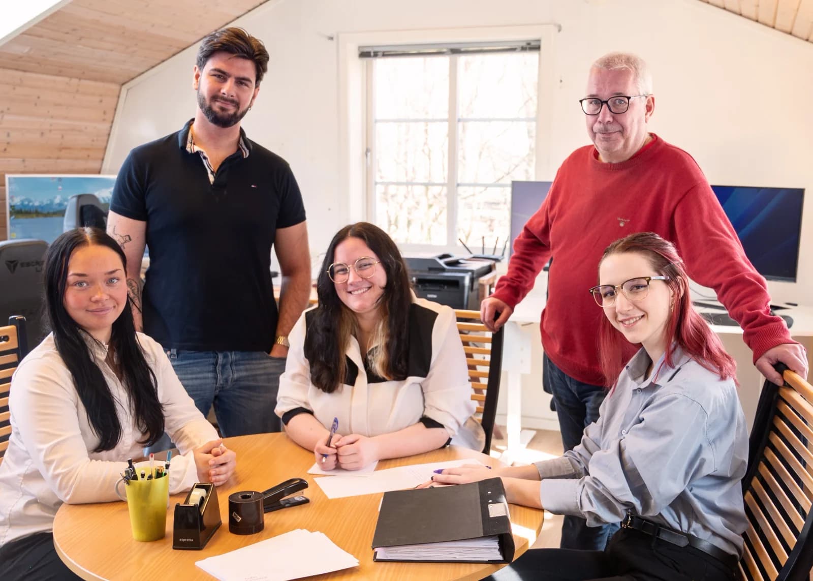 Teamet samlat kring bordet på kontoret